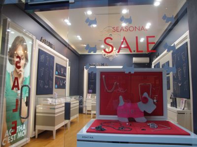 Red vinyl die cut window sticker saying seasonal sale