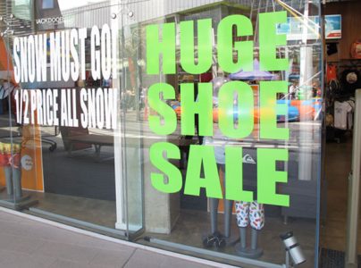 Green vinyl die cut window sticker saying huge shoe sale