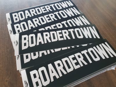 Large stack of black boardertown screenprinted bumper stickers